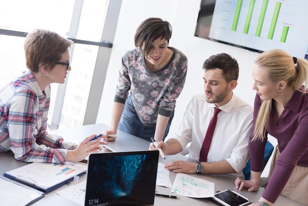 startupowy biznes, młodzi kreatywni ludzie grupują się w burzę mózgów podczas spotkania we wnętrzu biura i używają laptopa i tabletu do notowania pomysłów, planów i projektów