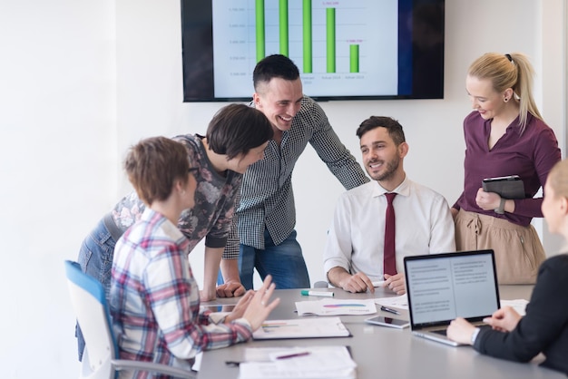 startupowy biznes, młodzi kreatywni ludzie grupują się w burzę mózgów podczas spotkania we wnętrzu biura i używają laptopa i tabletu do notowania pomysłów, planów i projektów