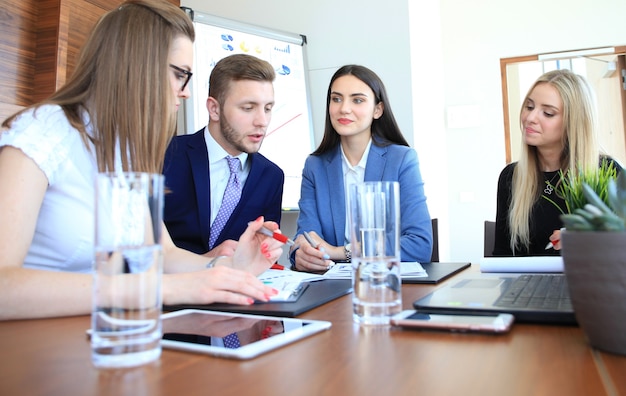 Zdjęcie startupowy zespół biznesowy na spotkaniu w nowoczesnym, jasnym wnętrzu biurowym, burza mózgów, pracująca na laptopie i tablecie