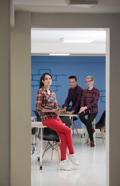 Startupowy zespół biznesowy na spotkaniu w nowoczesnym, jasnym wnętrzu biurowym, burza mózgów, pracujący na laptopie i tablecie