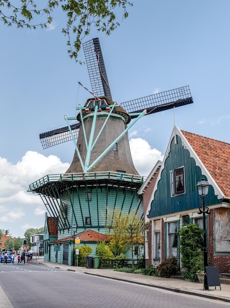 Stary autentyczny wiatrak na ulicy w pobliżu zabytkowej wioski Zaanse Schans w pobliżu Amsterdamu Holandia