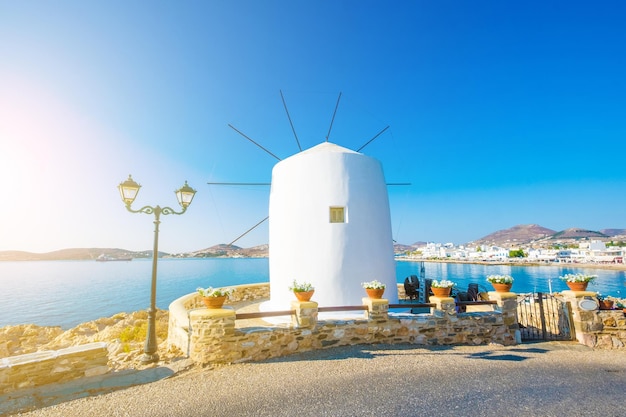 Stary biały wiatrak na klifie nad wodą Grecja