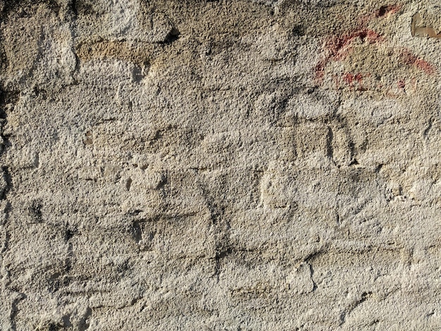 Stary ceglany mur pokryty cienką warstwą tynku Nierówna powierzchnia Tekstura tło