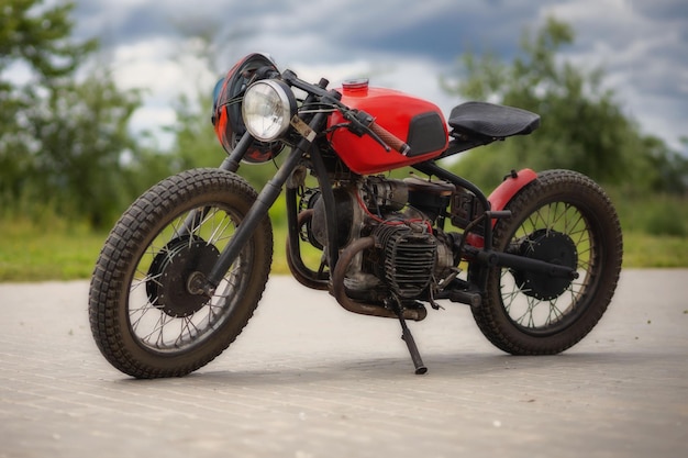Stary czerwony motocykl na parkingu.