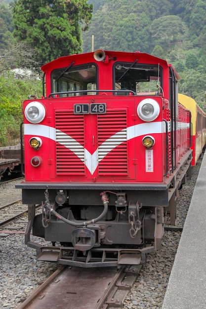 Stary czerwony pociąg w linii Alishan (w dół) wraca do dworca Chiyi w mglisty dzień.