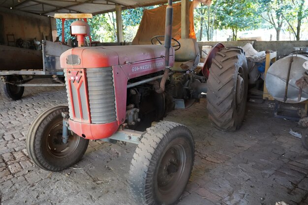 stary czerwony traktor parkujący na ranczo