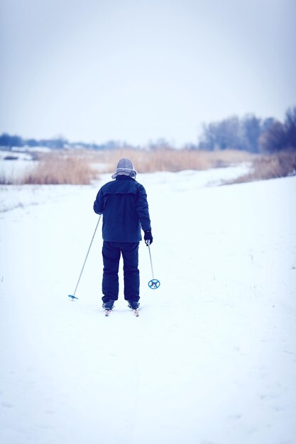 Zdjęcie stary człowiek ćwiczy, aby poprawić swoje zdrowie, jeżdżąc na nartach biegowych.