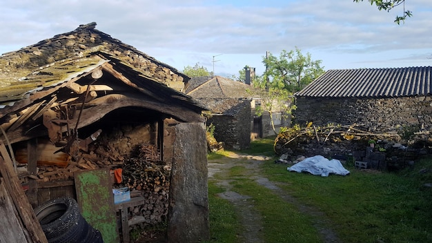 Zdjęcie stary dom na polu przy budynku przeciwko niebu