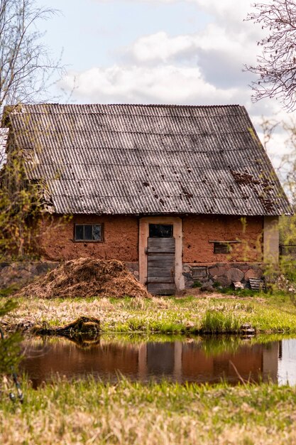 Zdjęcie stary dom wykonany z gliny w pobliżu wody na tle nieba