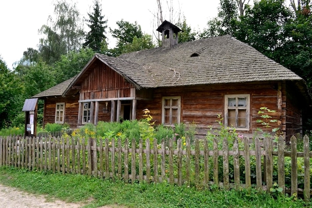 Stary drewniany dom z dachem krytym strzechą na wsi Wiejski dom