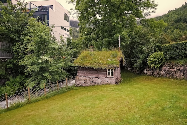 Stary drewniany dom z dachem z trawy w Geiranger Norwegia Tradycyjna norweska wioska dom na letnim krajobrazie Architektura tradycja projekt Wakacje wanderlust podróż Podróż odkrycie podróż