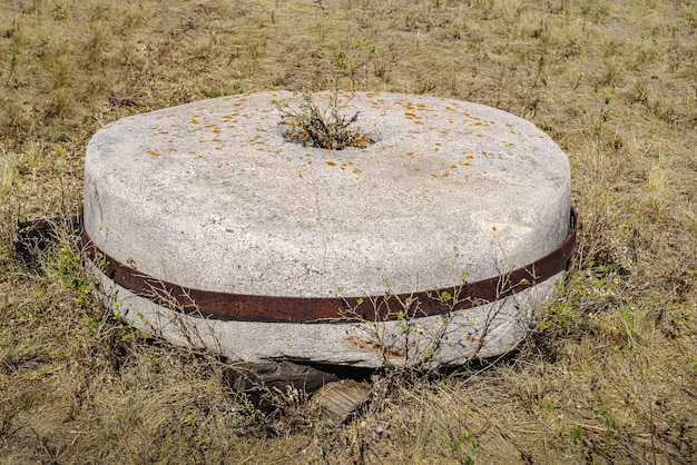 Stary kamień młyński z wiatraka leżącego na trawie. Obwód czelabiński, Rosja