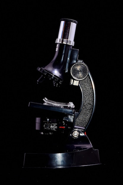 Stary mikroskop vintage na białym tle na czarnym tle