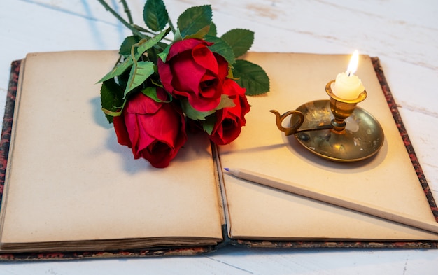 Stary notatnik, róże i mała świeczka, pojęcie romantyczny