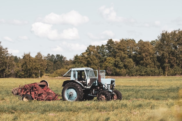 Stary radziecki traktor z montażem w polu