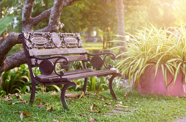 Stary styl vintage drewniana ławka lub krzesło w parku ze światłem słonecznym