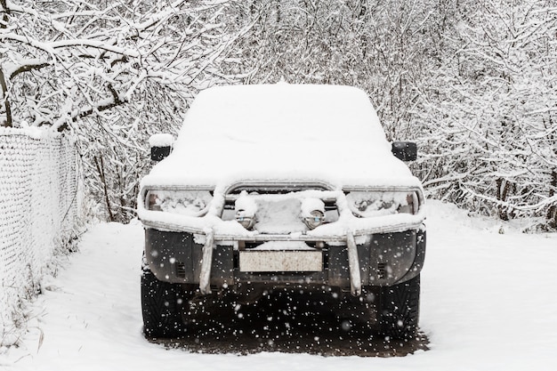 Stary SUV pokryty pierwszym śniegiem.