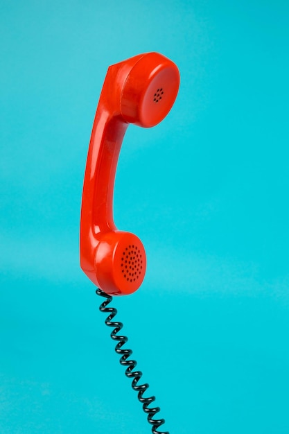 Zdjęcie stary telefon na niebieskim tle antyczny telefon z tubą czerwony telefon ze słuchawką