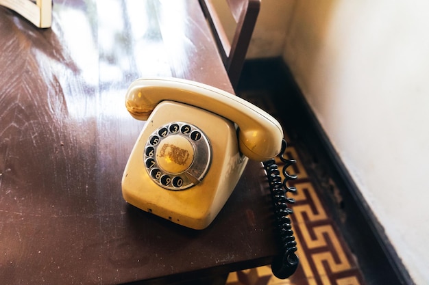 Zdjęcie stary telefon obrotowy na drewnianym stole stary żółty telefon retro czerwony telefon na drewnianym stole