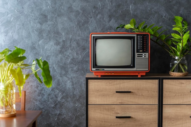 Stary telewizor na drewnianej szafce w pokoju w domu Ściana na poddaszu Ciepła atmosfera
