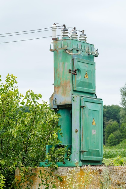 Stary transformator wysokiego napięcia i linia energetyczna