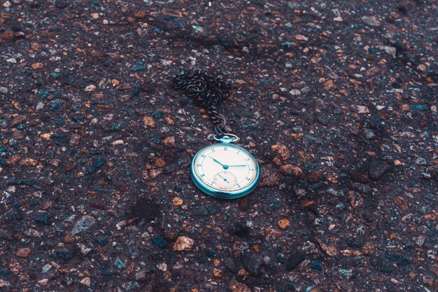 Zdjęcie stary zegarek kieszonkowy na ziemi koncepcja czasu