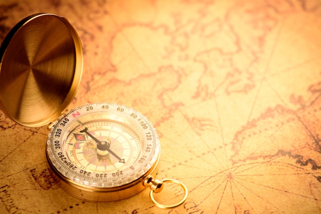 Stary złoty vintage kompas na vintage mapie: kierunek na południe
