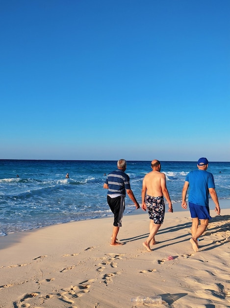 Zdjęcie starzy przyjaciele na zawsze chodzący po plaży