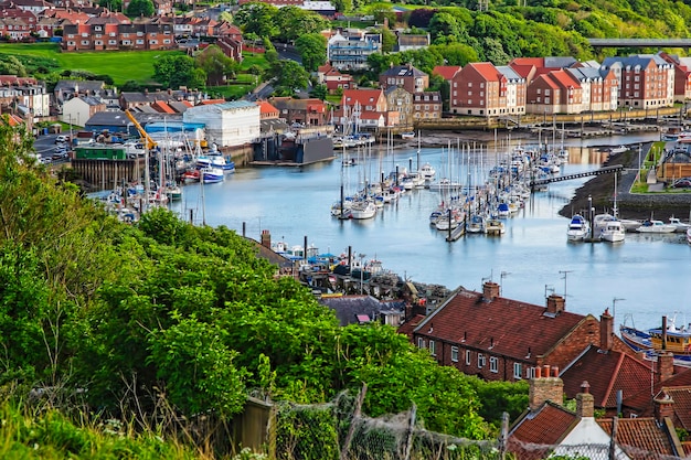 Statki w linii brzegowej Whitby w North Yorkshire w Anglii. Whitby to nadmorski port i miasto na wybrzeżu rzeki Esk.