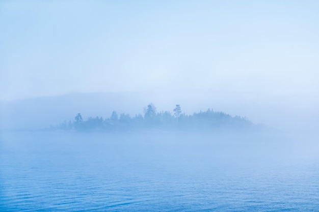 Staw lub jezioro z mgłą i niewyraźną wyspą