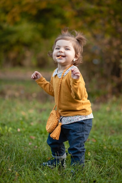 STAWROPOL, ROSJA, 5 PAŹDZIERNIKA 2019; Mała dziewczynka z torebką z dzianiny spaceruje po parku