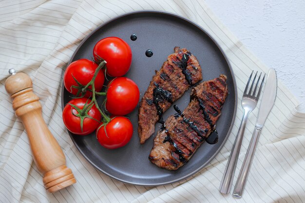 Stek wieprzowy z pomidorami. stek wieprzowy w koncepcji domowej żywności. Wygląd menu restauracji.