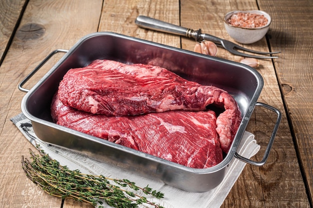 Stek wołowy Tri Tip w stalowej tacy surowe mięso najwyższej jakości Drewniane tło Widok z góry