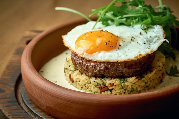 Stek wołowy z kaszą bulgur w sosie śmietanowym, jajkiem, rukolą.