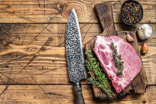 Steki wieprzowe świeże surowego mięsa na deska do krojenia z nożem