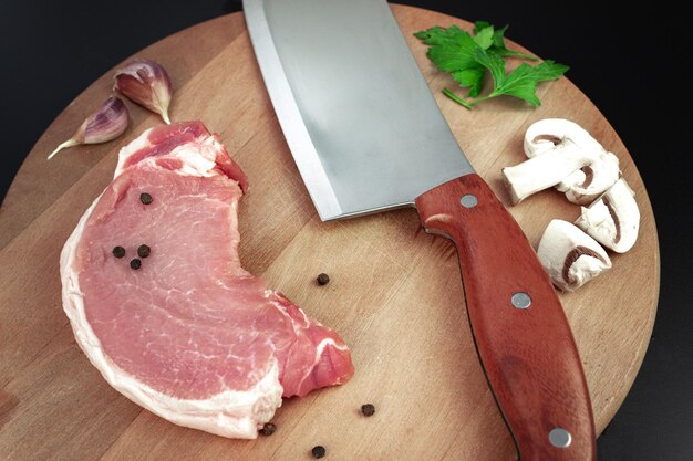 Steki z surowego mięsa z nożem do mięsa na kuchennej desce do krojenia