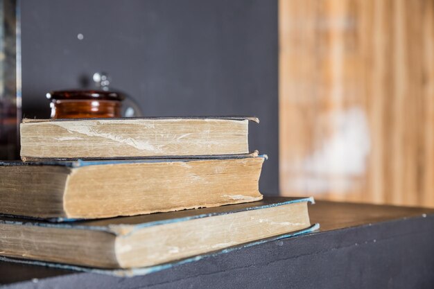 Sterta książek z rozmytym tłem stare książki na drewnianych półkach w bibliotececzytanie i pisanie