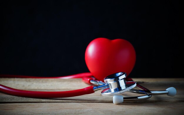 Steth i czerwony kształt serca na drewnianym stole koncepcja zdrowej opieki