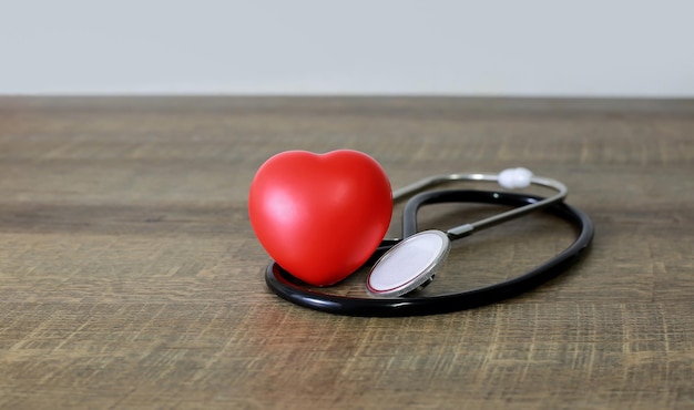 Stetoskop i badanie serca czerwone na starej drewnianej podłodze koncepcji opieki zdrowotnej