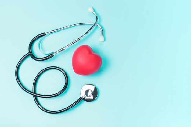Stetoskop i czerwone serce na niebieskim tle widok z góry miejsca na kopię