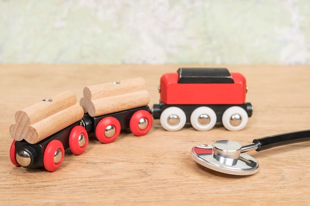 stetoskop i zabawkowy pociąg na starym drewnianym stole