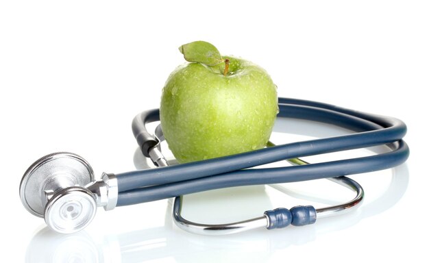 Zdjęcie stetoskop medyczny i zielone jabłko wyizolowane na białym