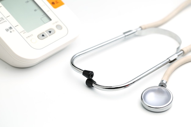 Zdjęcie stetoskop z elektronicznym ciśnieniomierzem lub ciśnieniomierzem na białym tle. pojęcie opieki zdrowotnej.
