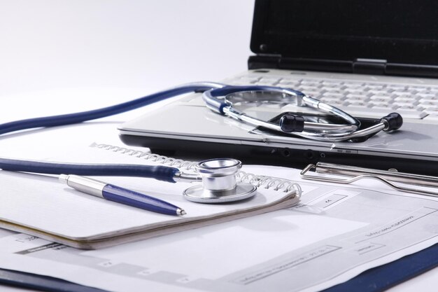 Zdjęcie stetoskop ze schowkiem i laptopem na biurku