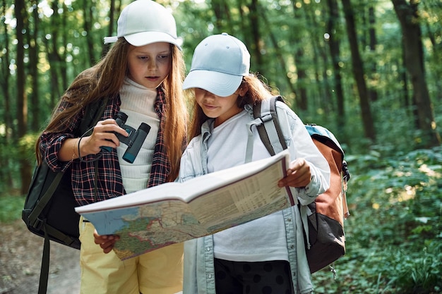 Zdjęcie stojąc na ścieżce dwie dziewczyny spędzają wolny czas w lesie, odkrywając nowe miejsca