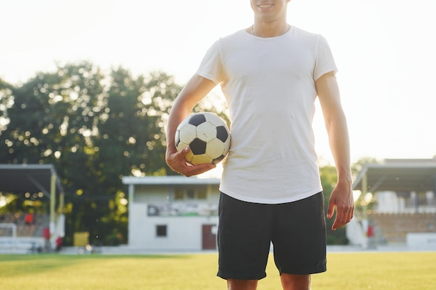 Stojący i pozujący Młody piłkarz trenuje na boisku sportowym