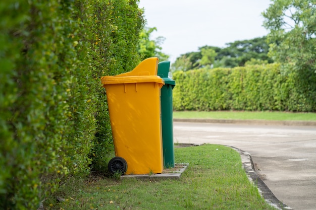 Stojący żółty i zielony kosz na śmieci na polu