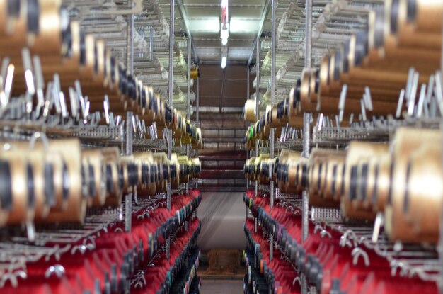 Zdjęcie stojak na nici do szycia na szpuli bawełnianej w fabryce tkania dywanów