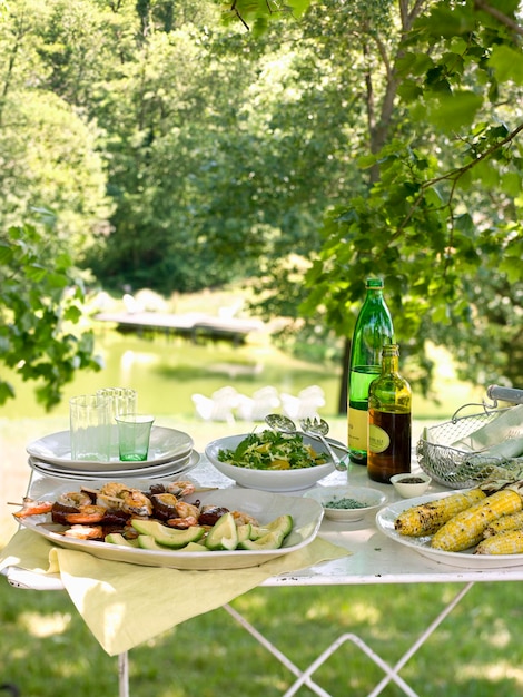 Stół bufetowy ustawiony w ogrodzie na posiłek na świeżym powietrzu Sałatki i dania gotowe