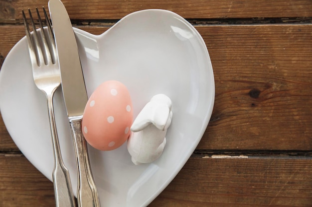 Stół do posiłku wielkanocnego ozdobiony wiosennym zajączkiem i jajkiem wielkanocnym